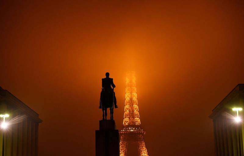 The top of the Eiffel tower in Paris is hidden by fog. Franck Fife / AFP Photo