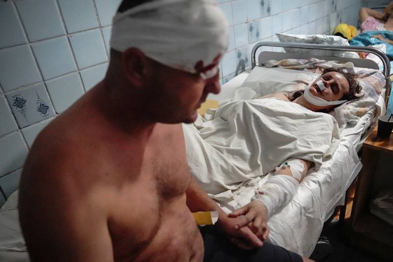 A couple wounded by a Russian missile strike hold hands in a hospital, in Kremenchuk. Reuters