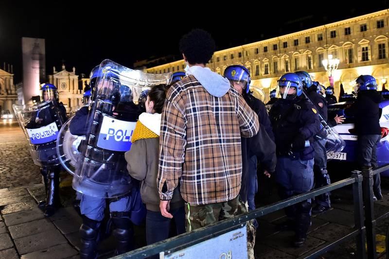 People stand in front of police officers during a protest against the new restrictions introduced by the government to curb the coronavirus disease (COVID-19) infections, in Turin, Italy, October 26, 2020. REUTERS/Massimo Pinca