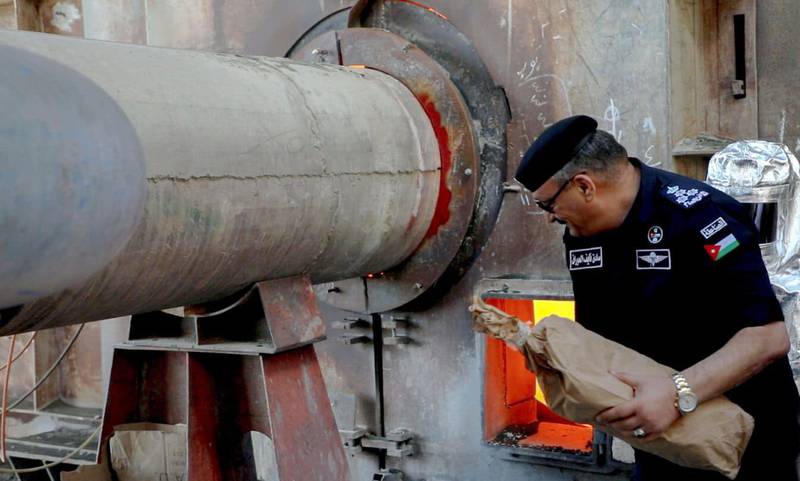 A Jordanian policeman carries a bag of seized drugs for destruction in a furnace. All Photos: General Security Directorate