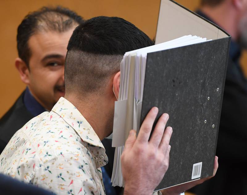 CORRECTION / The Iraqi defendant, identified only as Taha al-J., believed to have belonged to the Islamic State (IS) jihadist group, hides his face before the start of his trial in which he is accused of genocide and murdering a young Yazidi girl, he held as a slave, on April 24, 2020 at the Higher Regional Court (OLG) in Frankfurt am Main. The 27-year-old Iraqi man is also accused of crimes against humanity, war crimes and human trafficking in the case, heard before Frankfurt judges. His wife, a German woman, has been on trial for a year at a Munich court. She too is charged with murdering the young Yazidi girl who the pair are believed to have allowed to die of thirst in the Iraqi city of Fallujah in 2015. / AFP / POOL / Arne Dedert
