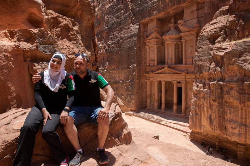 epa08498827 Jordan domestic tourists pose for a souvenir photo in front of the Treasury building at the reopened Petra archeological site, in Petra, some 280 km south of Amman, Jordan, 20 June 2020. Petra archeological site is one of the landmarks of Jordan tourism sector, the former Nabatean capital which dates back to about 200 BC, attracted in 2019, according to official figures, about 1,13 million visitors from all over the world. Following the start of the COVID-19 coronavirus pandemic in Jordan, the last tourist left Petra on 16 March. Since then its some 200 guides, 1,500 horse and donkey owners, hotels, restaurant and tourist stalls workers stayed without a fixed revenue. As Jordan tourism sites have officially reopened to domestic tourism on 16 June, locals flocked on 20 June to visit Petra in quiet surroundings without the big tourist buses.  EPA/ANDRE PAIN