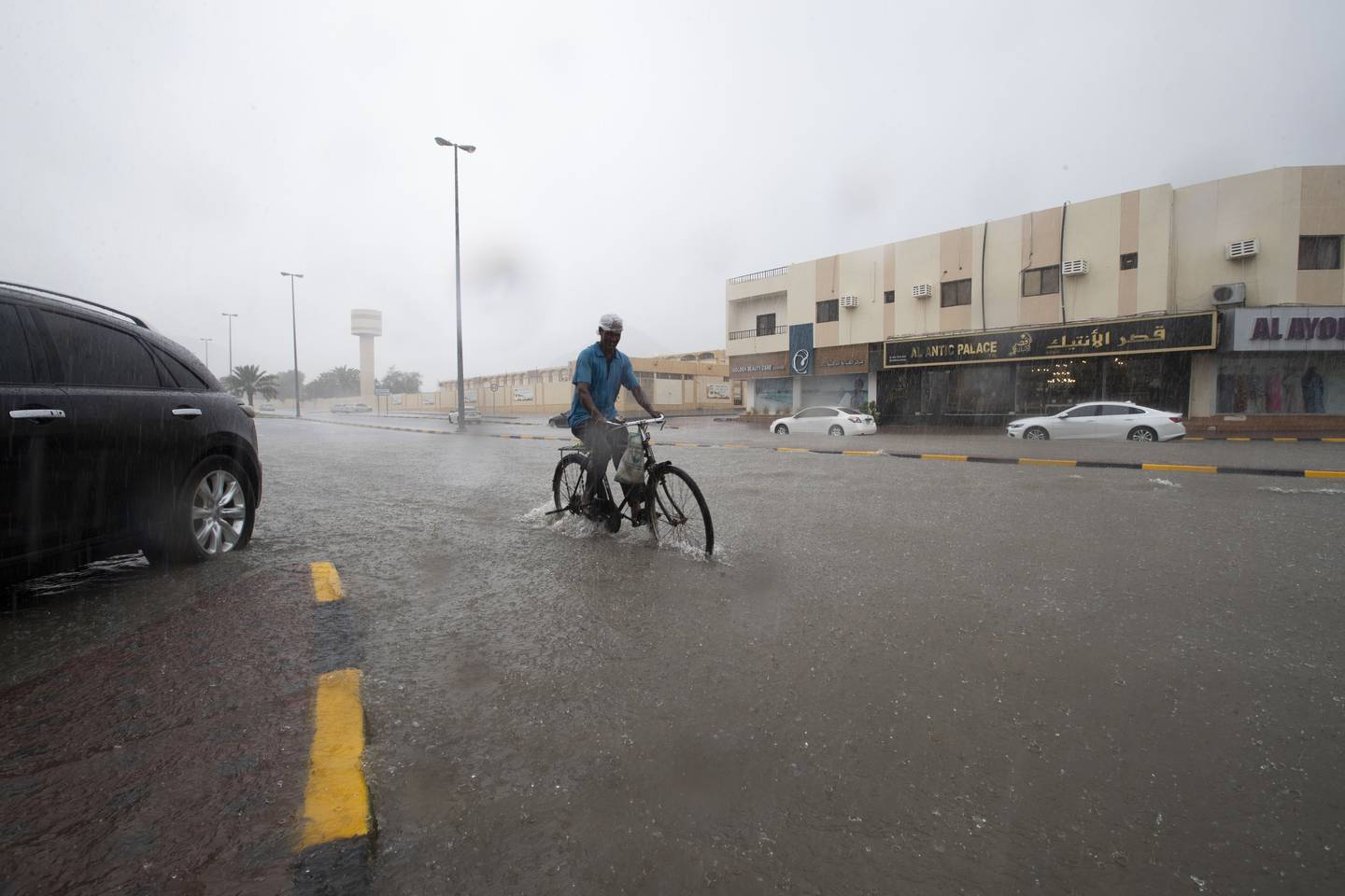 A cyclist navigates a flooded road in Khor Fakkan. Ruel Pableo for The National