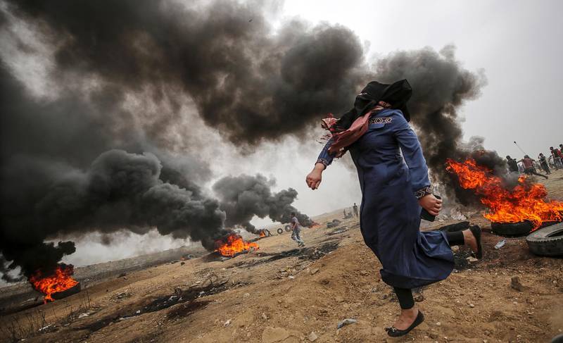 A female Palestinian protester throws stones during clashes after Friday protests near the border with Israel in eastern Gaza City. Mohammed Saber / EPA