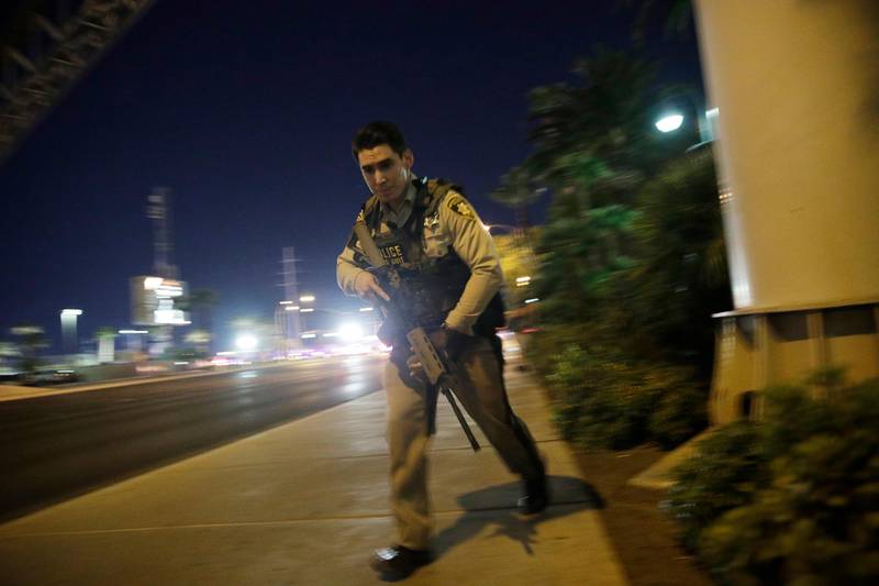 A police officer runs along a sidewalk near a shooting near the Mandalay Bay resort and casino on the Las Vegas Strip. John Locher / AP Photo