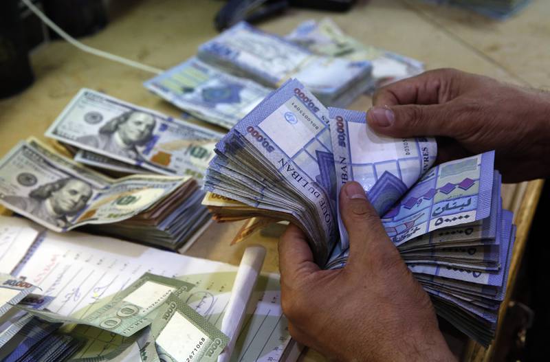A man counts Lebanese pounds at an exchange shop in Beirut. The caretaker government is to reset the country's exchange rate. AP