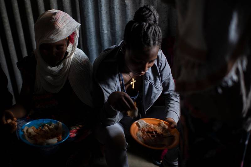 Displaced Tigrayan women sit in a metal shack to eat food donated by local residents at a reception center for the internally displaced in Mekele, in the Tigray region of northern Ethiopia. AP Photo