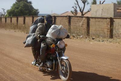 A motorcycle taxi rides past the Government Science Secondary School in Kankara, Nigeria. AP Photo