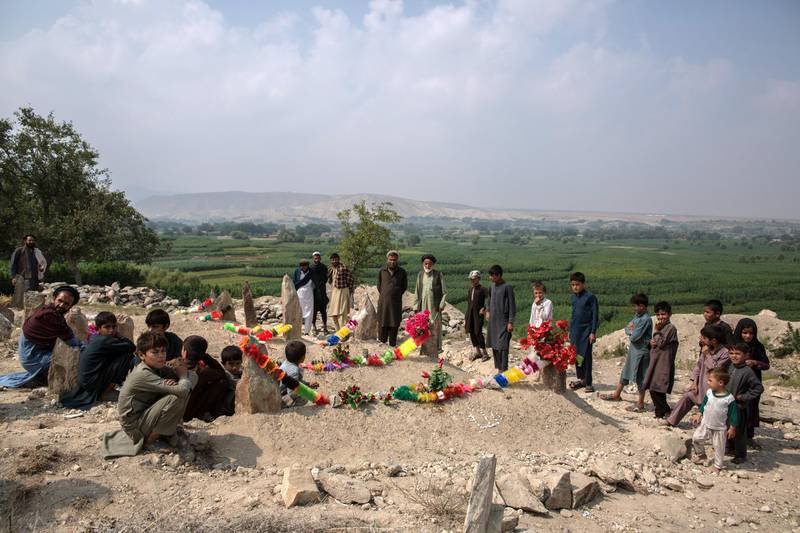 Families sit by the graves of relatives killed in a US drone strike on September 19, 2019, in Javari village in Afghanistan's Nangarhar province. Photos by Stefanie Glinski for The National