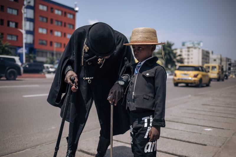 A dandy, or sapeur, and his son during a gathering in Kinshasa, capital of the Democratic Republic of Congo, on Friday. The event marks death of Stervos Niarcos, a pop star and one of the most famous of Congo's dandies. AFP
