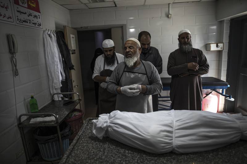 The body of Palestinian Muhammad Hassouna, who was killed in an Israeli air strike, is prepared for his funeral at a hospital in Rafah. AP
