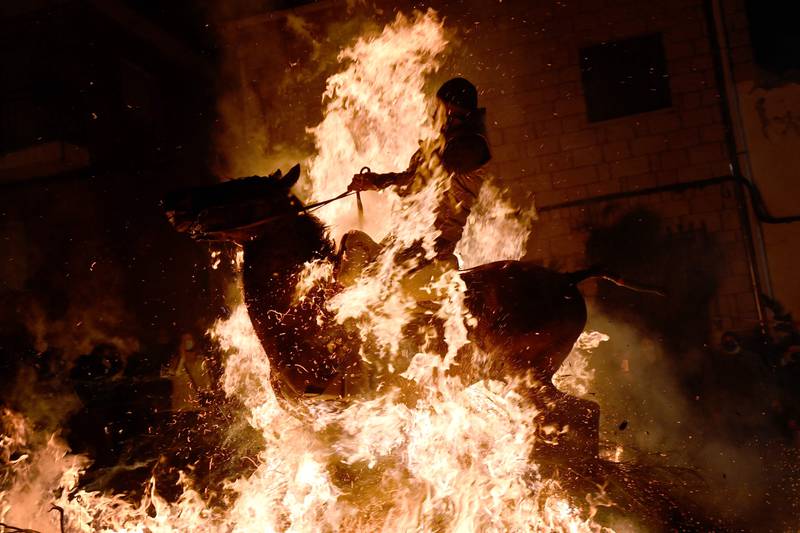 A horseman rides through a bonfire in the village of San Bartolome de Pinares in the province of Avila in central Spain, during the religious festival of 'Las Luminarias' in honour of San Antonio Abad, patron saint of animals. AFP