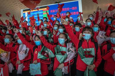Medical workers from The First Bethune Hospital of Jilin University cheer during a ceremony at the airport as they prepare to leave after the lockdown was lifted in Wuhan, China.  EPA