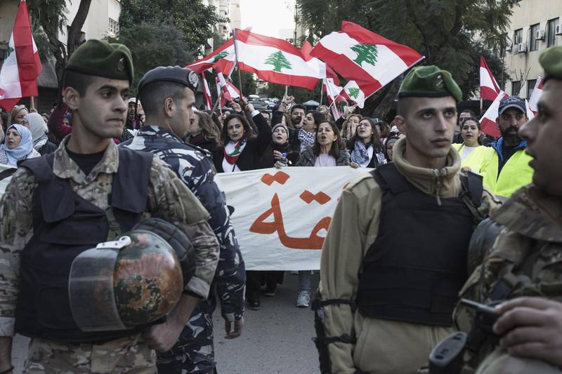 Lebanese security forces walk in front of anti-government protesters as they march toward the Parliament on January 25, 2020 in Beirut. Getty Images