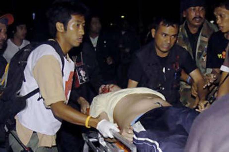 An injured anti-government protester is wheeled on a stretcher to a waiting ambulance after a bomb attack at their protesting ground of government house in Bangkok, Thailand Saturday, Nov 22 2008. A grenade attack on protesters occupying the Thai prime minister's office wounded eight people early Saturday, officials said.