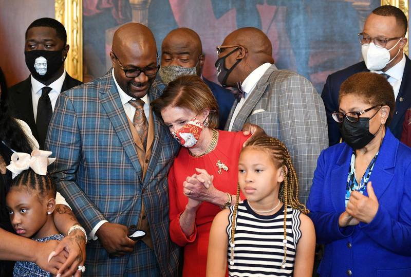 Philonise Floyd, brother to George Floyd, puts his arm around Speaker Nancy Pelosi, near Rep. Karen Bass, as he and other members of the Floyd family meet politicians at the US Capitol. Reuters