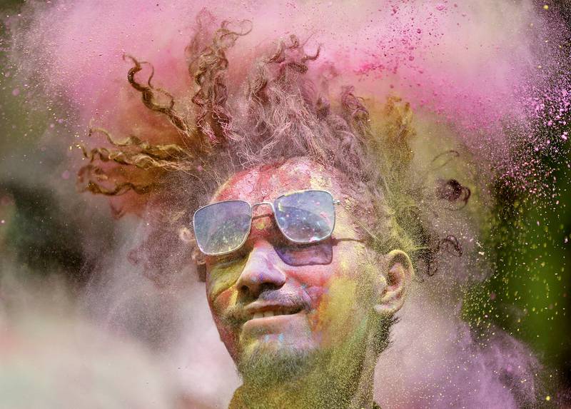A man covered in coloured powder shakes his head during Holi celebrations in Ahmedabad, India. Reuters