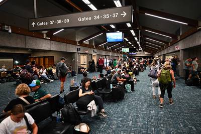 Passengers try to rest at Kahului Airport as they leave Maui. AFP