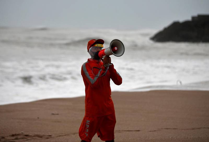 A member of the National Disaster Response Force appeals to fishermen to stay away from the shore as cyclone Tauktae bears down on Veraval in the western state of Gujarat. Reuters