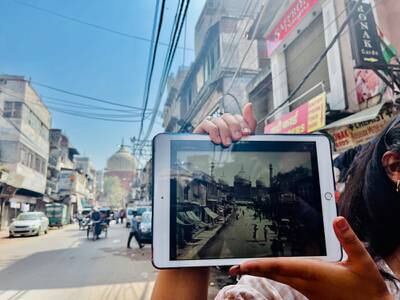 The road leading to Jama Masjid in old Delhi, with guide Anoushka Jain showing an old picture of the same road in the 19th century. Sonia Sarkar for The National