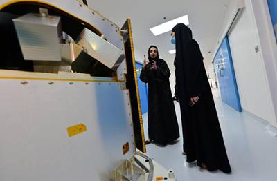 Engineers observe a KhalifaSat model. AFP