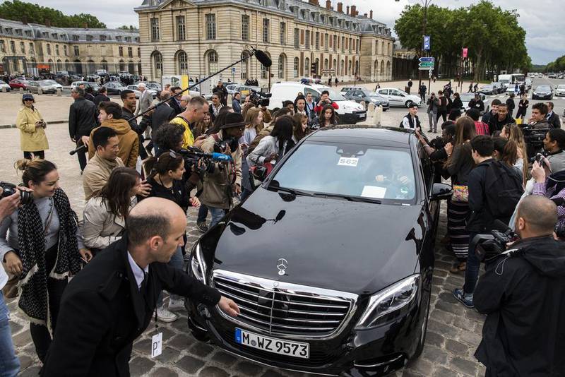 Fans surround a car carrying guest as it arrives for a private tour of the Palace of Versailles on the eve of the wedding of Kim Kardashian and Kanye West, in Versailles, near Paris, France, on May 23, 2014. Etienne Laurent / EPA