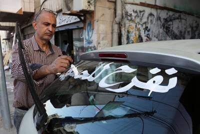 A man paints a car with 'celebrating Al Hussein'. Reuters