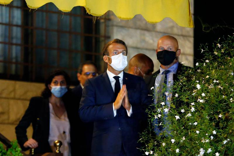 French President Emmanuel Macron gives a respect sign to anti-government protesters as he leaves the house of Fairouz. AP