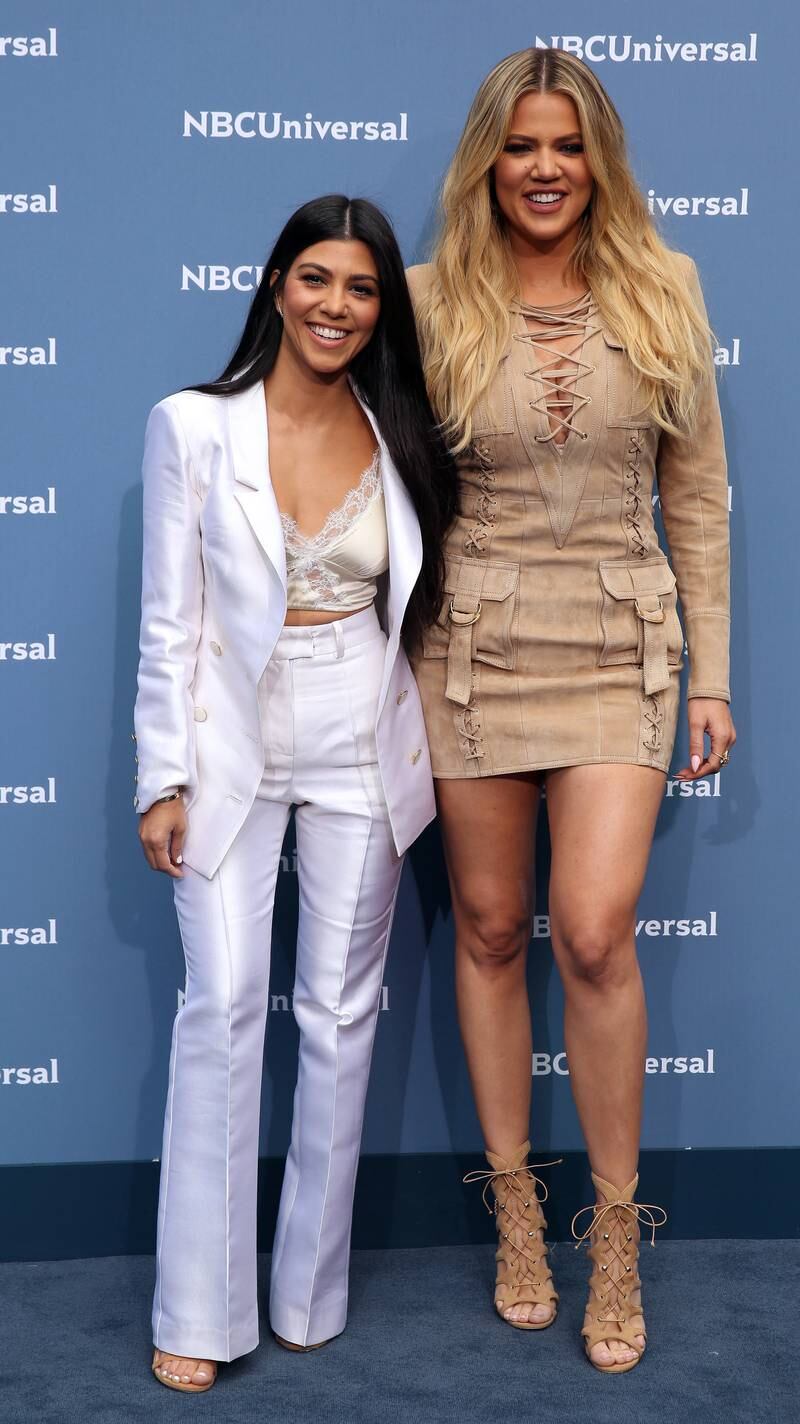 Kourtney Kardashian, left, in a white suit, with Khloe Kardashian, arrives at the 2016 NBCUniversal Upfront Presentation in New York on May 16, 2016. EPA