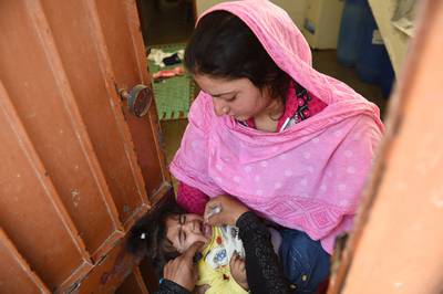 A Pakistani health worker administers polio drops during a door-to-door immunisation campaign in Karachi.  Asif Hassan / AFP