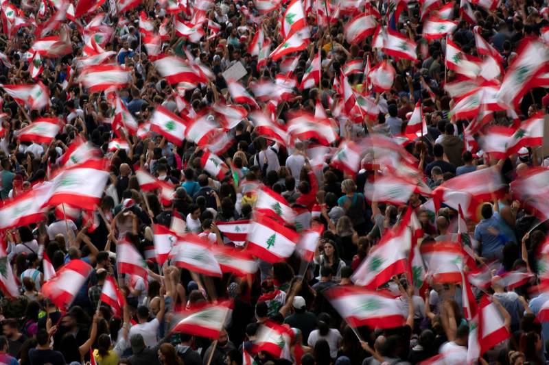 Demonstrators wave Lebanese national flags during ongoing anti-government protests at a highway in Jal El Dib, Lebanon.  Reuters