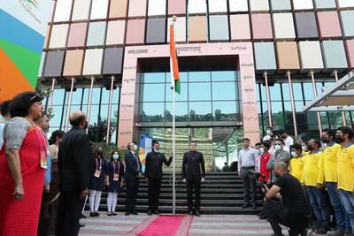 Consul General of India Dr Aman Puri, centre-right, hoists a flag.