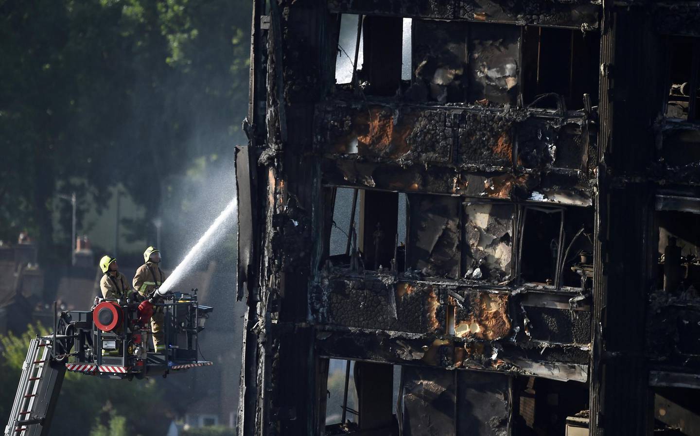 FILE PHOTO: Firefighters spray water onto the Grenfell Tower block which was destroyed in a disastrous fire, in north Kensington, West London, Britain June 16, 2017. REUTERS/Hannah McKay/File Photo