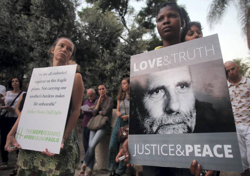 Women hold placards during a vigil in solidarity with Italian Jesuit priest Father Paolo Dall'Oglio and the Syrian people on July 29, 2015 in front of the Jesuit Church in the Lebanese capital Beirut. Father Paolo Dall'Oglio disappeared on July 29, 2013 in the northern Syrian city of Raqqa, where he went to negotiate with jihadists.  AFP PHOTO / STR / AFP PHOTO / -