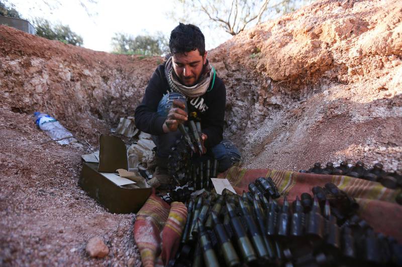 Turkish-backed Syrian fighter loads ammunition at a frontline near the town of Saraqib in Idlib province, Syria. AP Photo