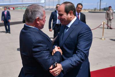 King Abdullah II, left, is welcomed by Egyptian President Abdel Fattah El Sisi before a trilateral Jordanian-Egyptian-Palestinian summit in El Alamein on Monday. Jordanian Royal Palace / AFP