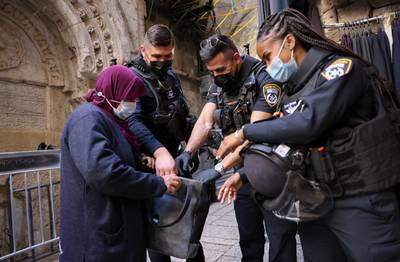 Israeli police officers check the bag of a Palestinian woman entering Al Aqsa Mosque during Ramadan last year. AFP