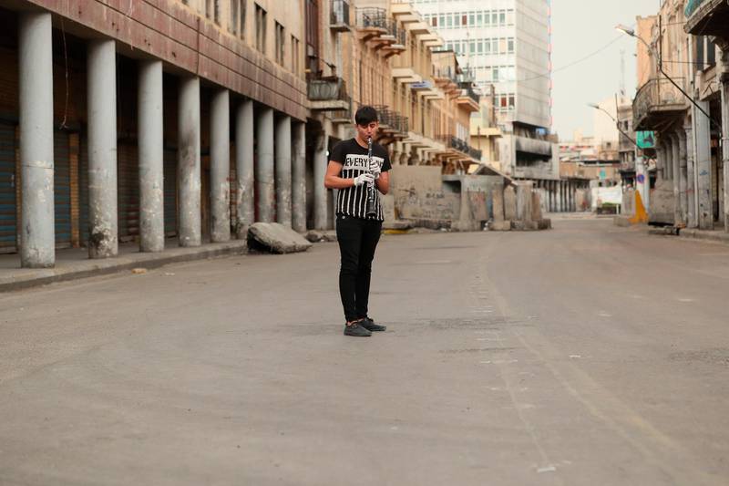 A man plays The national anthem on the flute in a nearly empty street in Baghdad, Iraq. AP Photo