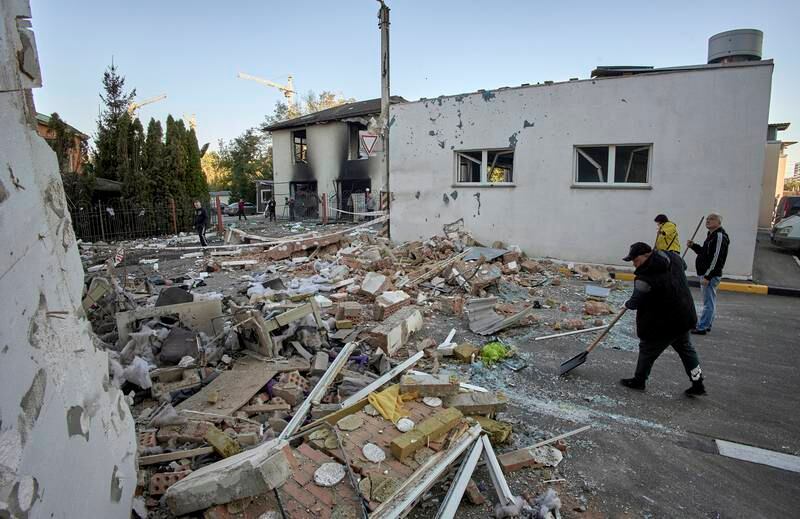 Workers clean debris after an administrative building was damaged in a rocket attack in Kharkiv. EPA