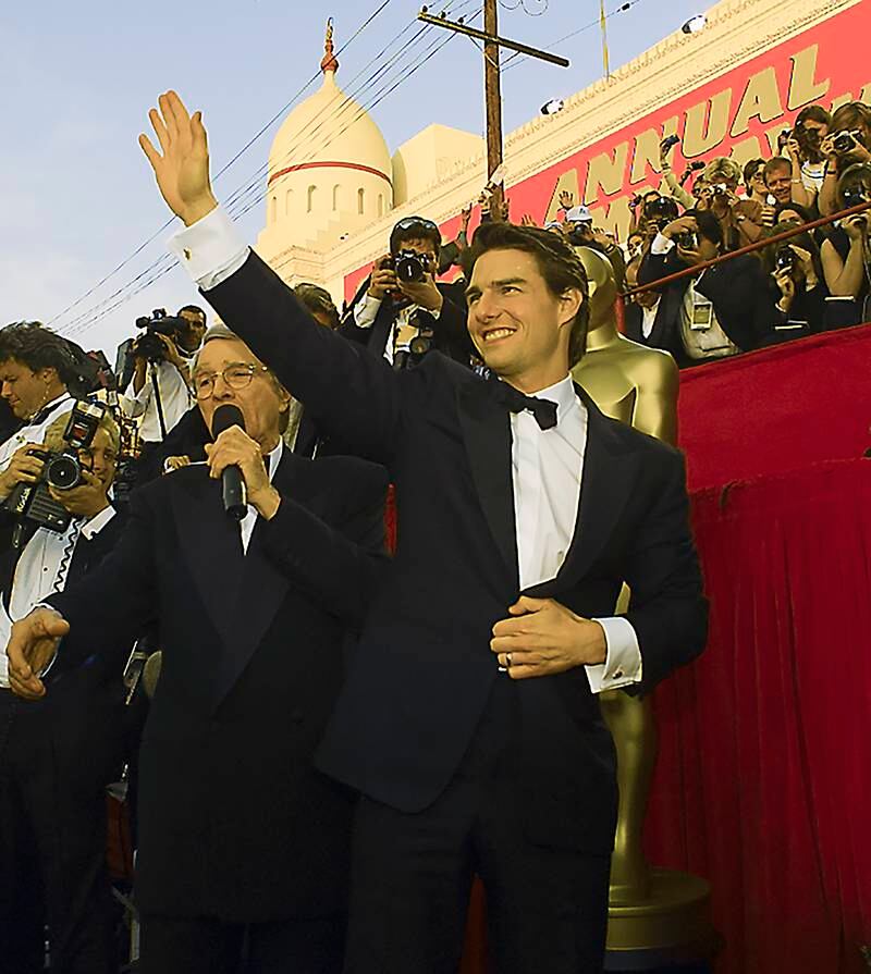 Tom Cruise, whose film Top Gun: Maverick is nominated for Best Picture at the 2023 awards, waves to fans on the red carpet at the 1997 ceremony