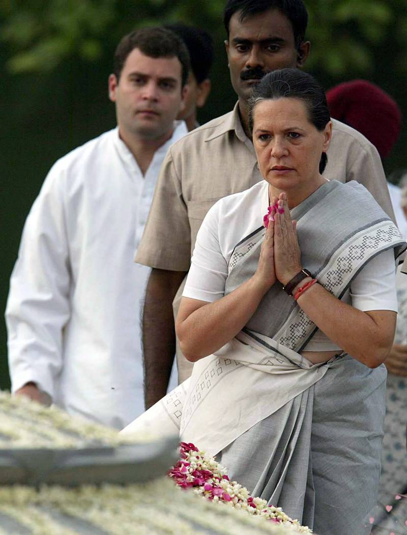 epa00195697 Congress President Sonia Gandhi (R) and her son Rahul Gandhi (L) pray at the memorial to her late husband and former prime minister Rajiv Gandhi in New Delhi, Friday 21 May 2004, marking his 13th death anniversary. Indias next Prime Minister Manmohan Singh's appointment on Wednesday ends a week of dramatic political turmoil in which Sonia Gandhi, the Italian born widow at the head of the countrys most powerful political dynasty, turned the job down.  EPA/HARISH TYAGI