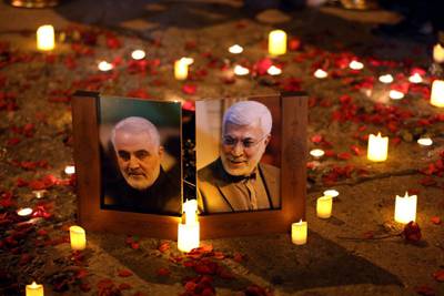 Photos of Qassem Suleimani, left, and Abu Mahdi Al Muhandis are placed on the road to Baghdad international airport during a commemoration of their deaths on January 2, 2020. EPA