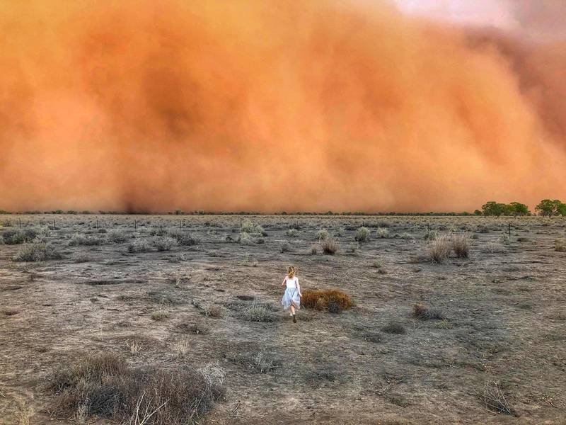 A child runs towards a dust storm in Mullengudgery in New South Wales. Dust storms hit many parts of Australia's western New South Wales as a prolonged drought continues. AFP