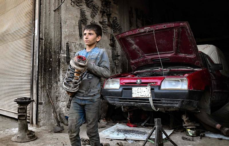 A young Syrian works at a car repair shop in Jandaris, near Afrin in the rebel-held part of Aleppo province, on June 11, 2022, a day before the annual World Day Against Child Labour. AFP