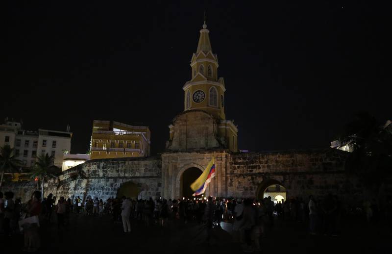 People gather in front of the Clock Tower that turned off its traditional lighting in Cartagena, Colombia. Ricardo Maldonado Rozo / EPA