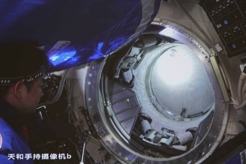 Chinese astronaut Chen Dong opens the hatch door of the Wentian lab module on July 25, 2022.  Photo:  Xinhua News Agency