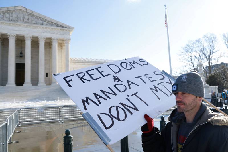 A protester stands outside the US Supreme Court as it hears arguments against the Biden administration's nationwide vaccine-or-testing Covid-19 mandates. Reuters