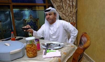 Saeed Al Musallam watches a Hindi TV station at his dining room table in Al Barsha. Antonie Robertson / The National