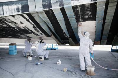 Workers sand off old paint on a yacht at the Gulf Craft factory. Sarah Dea / The National