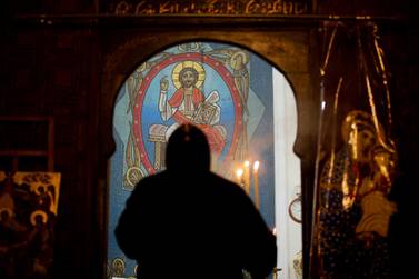 A priest leads prayers prior to Christmas Eve Mass at the Virgin Mary church, in Cairo, Egypt. AP